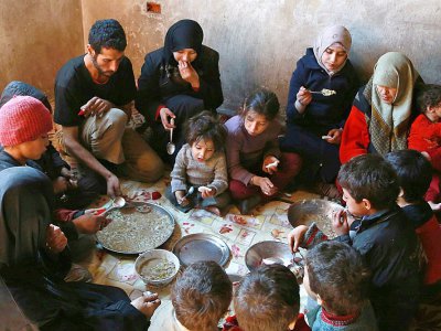 Une famille partage un maigre repas à base de choux et de maïs dans la Ghouta orientale assiégée près de Damas, le 6 novembre 2017 - ABDULMONAM EASSA [AFP]