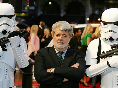 Le réalisateur américain George Lucas, encadré par des personnages de sa saga "Star Wars", lors d'une première à Londres le 16 mai 2005. - JOHN D MCHUGH [AFP/Archives]