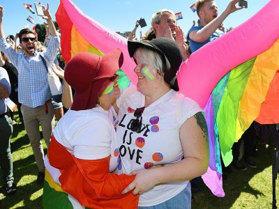 Un couple de même sexe s'embrasse le 15 novembre 2017 à Sydney à l'annonce de la victoire du "oui" au mariage gay lors d'une vote postal - WILLIAM WEST [AFP]