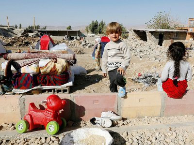 Photo prise le 15 novembre 2017 à Kouik, dans l'ouest de l'Iran, montrant des enfants près des gravats de leur maison après le séisme du 12 novembre - ATTA KENARE [AFP]