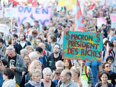 Des manifestants brandissent une pancarte "Macron president des riches" lors d'une manifestation à Paris le 23 septembre 2017 - GEOFFROY VAN DER HASSELT [AFP/Archives]