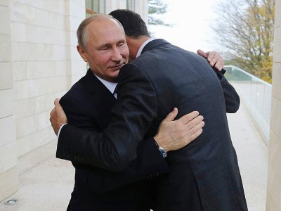 Le président russe Vladimir Poutine (D) donne l'accolade à son homologue syrien Bachar al-Assad à Sotchi (Russie), le 20 novembre 2017 - Mikhail KLIMENTYEV [SPUTNIK/AFP]