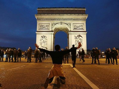 Un manifestant à genoux sur la place de l'Étoile à Paris, pour protester contre "l'esclavage en Libye", le 18 novembre 2017 - Zakaria ABDELKAFI [AFP/Archives]