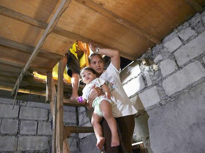 Myrna Albos, avec son enfant dans sa bicoque, dans un bidonville à la périphérie de Manille, le 10 octobre 2017 - Ted ALJIBE [AFP]