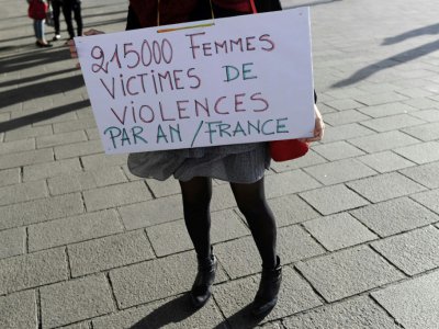 Une femme tient un panneau où l'on peut lire "21.500 femmes victimes de violence par an en France", sur le Vieux Port à Marseille, lors d'un rassemblement contre les violences faites aux femmes le 29 octobre 2017 - Franck PENNANT [AFP]