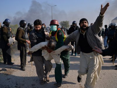 Des manifestants islamistes transportent un blessé lors de heurts avec la police pakistanaise, le 25 novembre 2017 à Islamabad - AAMIR QURESHI [AFP]