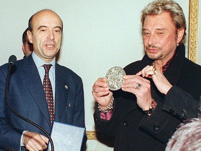 Le maire de Bordeaux, Alain Juppé, remet la médaille de "Bordeaux Ville d'art" à Johnny Hallyday, le 28 novembre à la mairie de Bordeaux - PATRICK BERNARD [AFP/Archives]
