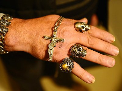 Un fan montre ses bijoux, des copies de ceux portés par son idole Johnny Hallyday, devant la maison du chanteur à Marne-la-Coquette, le 6 décembre  2017 - NICOLAS TUCAT [AFP]