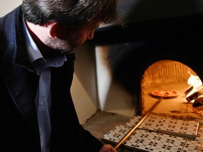 Le ministre de la Culture italien Dario Franceschini sort une pizza du four, au musée Capodimonte de Naples, le 6 décembre 2017 - TIZIANA FABI [AFP/Archives]