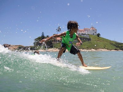 Daniel Cortinhas, 9 ans, surfe sur une vague au large de Saquarema, dans l'Etat de Rio, au Brésil, le 29 novembre 2017 - LEO CORREA [AFP]