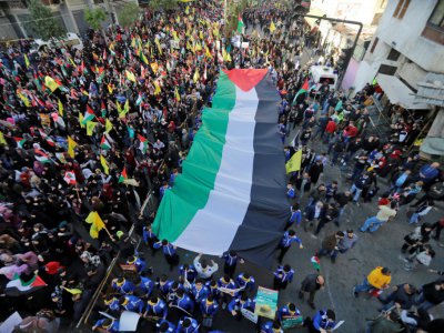Des partisans du mouvement libanais Hezbollah défilent avec un drapeau palestinien géant à Beyrouth le 11 décembre 2017 - Joseph EID [AFP]