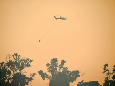 Un hélicoptère participe à la lutte contre l'incendie qui ravage Carpinteria, en Californie, le 12 décembre 2017 - Robyn Beck [AFP]