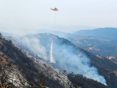 Un hélicoptère lâche de l'eau sur les collines de Toro Canyon, au nord de Santa Barbara, en Californie, le 12 décembre 2017 - FREDERIC J. BROWN [AFP]