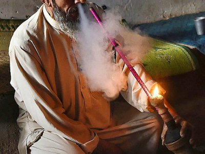 Un Pakistanais fume une pipe de haschich, le 25 octobre 2017 à Peshawar - ABDUL MAJEED [AFP]