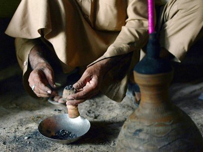 Un Pakistanais prépare une pipe de haschich, le 25 octobre 2017 à Peshawar - ABDUL MAJEED [AFP]