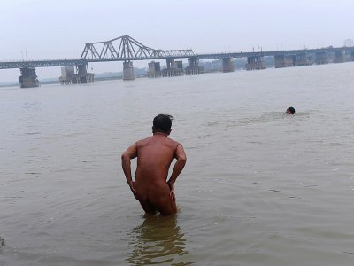 Des adeptes du naturisme se baignent dans le fleuve Rouge, le 11 décembre 2017 à Hanoï, au Vietnam - HOANG DINH NAM [AFP]