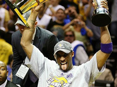 Kobe Bryant brandit les trophées de meilleur joueur des finales (MVP), ainsi que de vainqueur du titre NBA, à l'issue de la victoire des Lakers à Orlando, le 14 juin 2009 - ELSA [Getty/AFP/Archives]
