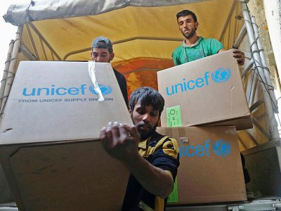 Des Syriens déchargent des cartons d'aide humanitaire, le 28 novembre 2017 à al-Nashabiyah, dans la Ghouta orientale - Amer ALMOHIBANY [AFP/Archives]