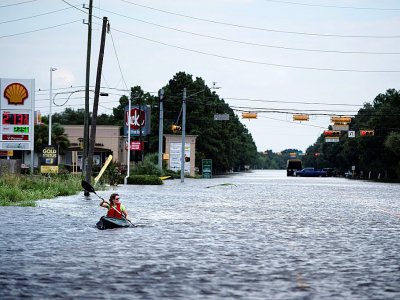 Une femme navigue dans un canoë sur une route inondée de Houston, après le passage de l'ouragan Harvey, le 30 août 2017 - Brendan Smialowski [AFP/Archives]