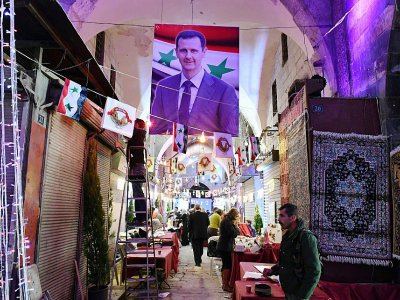 Un portrait du président syrien Bachar al-Assad supendu dans le souk historique d'Alep, décoré avant sa réouverture, le 16 novembre 2017 - George OURFALIAN [AFP]