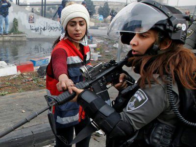 Une Palestinienne protestant contre la reconnaissance par les Etats-Unis de Jérusalem comme capitale d'Israël fait face à une garde-frontière israélienne lors de heurts à Ramallah en Cisjordanie, territoire palestinien coccupé par Israël, le 22 décem - ABBAS MOMANI [AFP]