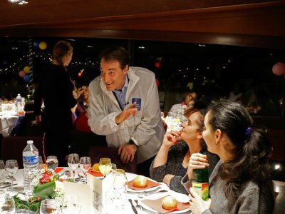 Bernard Thibaud, secrétaire général du Secours Catholique, avec des invités lors d'une croisière caritative annuelle sur la Seine à Paris, le 24 décembre 2017 - FRANCOIS GUILLOT [AFP]