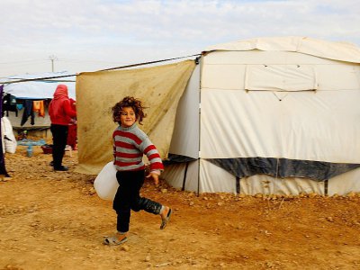 Une fillette syrienne déplacée par les combats porte un jerrycan dans le camp d'Aïn Issa dans le nord d ela Syrie, le 18 décembre 2017 - Delil souleiman [AFP]