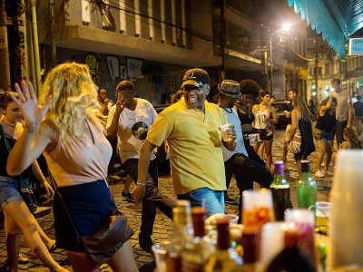 Touristes et habitants locaux dansent dans le quartier Quilombo Pedra do Sal à Rio de Janeiro, au Brésil, le 18 décembre 2017 - MAURO PIMENTEL [AFP]