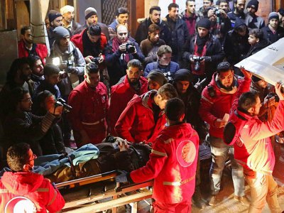 Des volontaires du Croissant-rouge syrien transportent un malade dans une ambulance pour l'évacuer de Douma vers Damas où il doit recevoir des soins, tard le 28 décembre 2017 - Amer ALMOHIBANY [AFP]
