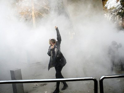 Une Iranienne dans la fumée de gaz lacrymogène lors de manifestations à l'université de Téhéran, le 30 décembre 2017 - STR [AFP]