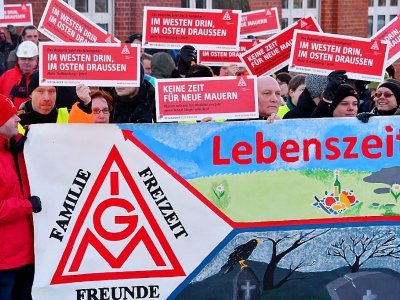 Des salariés d'une usine Bombardier brandissent des pancartes portant le logo du syndicat allemand de la métallurgie IG Metall lors d'un débrayage à Hennigsdorf près de Berlin, le 8 janvier 2018 - Bernd Settnik [dpa/AFP]