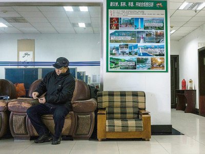 Le propriétaire nord-coréen d'une agence de voyage est dans son bureau à Dandong, le 9 janvier 2018 - CHANDAN KHANNA [AFP]