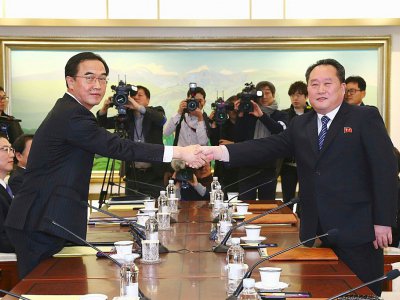 Le ministre sud-coréen de l'Unification Cho Myung-Gyun (G) serre la main du responsable de la délégation nord-coréenne Ri Son-Gwon (D) lors d'une rencontre à Panmunjom, le 9 janvier 2018 - KOREA POOL [KOREA POOL/AFP]
