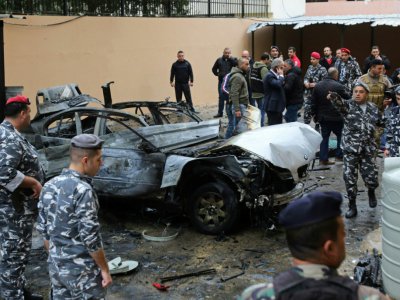 Des forces de sécurité libanaises devant la carcasse d'un véhicule après l'explosion d'une bombe, le 14 janvier 2018 à Saïda - Mahmoud ZAYYAT [AFP]