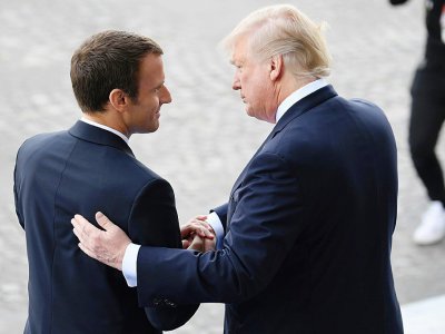 Emmanuel Macron et Donald Trump se serrent la main se serrent la main lors du défilé du 14 juillet 2017, à Paris - ALAIN JOCARD [AFP/Archives]