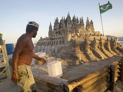 Le Brésilien Marcio Mizael Matolias travaille sur son château de sable, le 18 janvier 2018 sur la plage de Barra da Tijuca, à Rio de Janeiro - MAURO PIMENTEL [AFP]