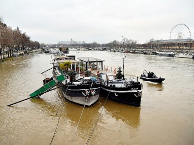 Les habitants des péniches amarrées sur les berges de la Seine ont installé des défenses afin que leurs bateaux n'aillent pas s'échouer sur les quais, à Paris le 22 janvier 2018 - CHRISTOPHE SIMON [AFP]