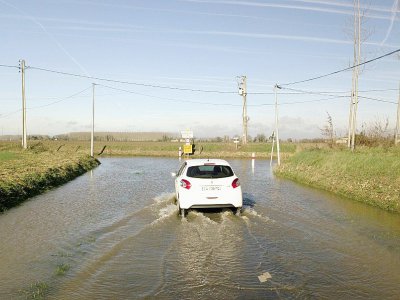 Une voiture roule sur une route inondée à Tonneins dans le Lot-et-Garonne le 24 janvier 2018 - MEHDI FEDOUACH [AFP]