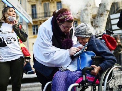 Une femme assiste une personne âgée, lors d'une manifestation à Paris, le 30 janvier 2018 - ANNE-CHRISTINE POUJOULAT [AFP]