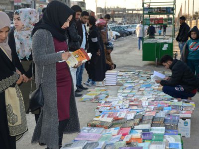 Des Irakiens vendent et achètent des livres sur un trottoir de Mossoul, dans le nord de l'Irak, le 12 janvier 2018 - Ahmad MUWAFAQ [AFP]