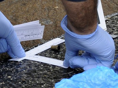Un policier scientifique examine la douille d'une balle tirée lors de la fusillade qui a blessé six Africains à Macerata, dans le centre de l'Italie, le 3 février 2018. - Giuseppe Bellini [AFP]