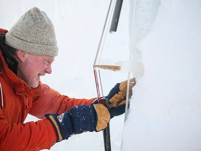 Un musicien prepare sa contrebasse pour participer à un concert de musique de chambre froide, dans un igloo près du village de Finse, le 2 février 2018 - Jonathan NACKSTRAND [AFP]