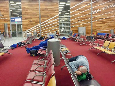 Des voyageurs dorment sur des banquettes à l'aéroport d'Orly après l'annulation de vols en raison de la neige, le 7 février 2018 - Ingrid BAZINET [AFP]