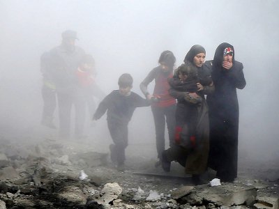 Une famille syrienne fuit les raids du régime à Jisrine dans la région rebelle de la Ghouta orientale près de Damas, le 8 février 2018 - ABDULMONAM EASSA [AFP]