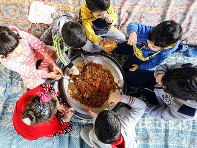 Des enfants mangent un couscous à Tripoli, en Libye, le 6 février 2018 - MAHMUD TURKIA [AFP]
