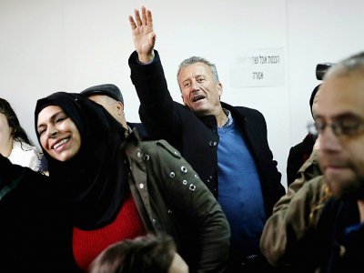 Photo du père d'Ahed Tamimi, Bassem (C), saluant sa fille de la main lors de l'ouverture du procès de la jeune palestinienne le 13 février 2018 devant le tribunal militaire d'Ofer, en Cisjordanie occupée - THOMAS COEX [AFP]