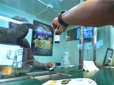 Le vendeur James Varnado répond à un client qui l'interroge sur un sirop au cannabis, dans la boutique de Virgil Grant, à Los Angeles le 8 février 2018 - Frederic J. BROWN [AFP]