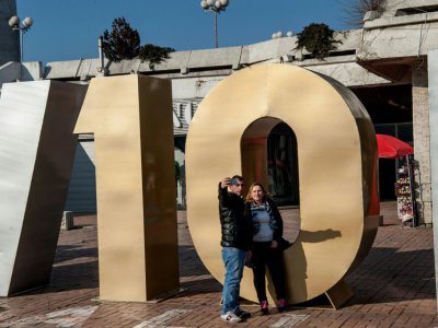 Un couple prend un selfie devant le monument à la "Renaissance" érigé pour le 10e anniversaire de l'indépendance du Kosovo à Pristina, le 17 février 2018 - Armend NIMANI [AFP]