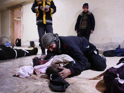 Un Syrien pleure la mort de son enfant tué dans les bombardements du régime, dans une morgue improvisée du village de Mesraba, dans la Ghouta orinentale  près de Damas, le 19 février 2018 - Hamza Al-Ajweh [AFP]