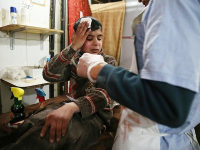 Ghaith, un adolescent de 12 ans, est soigné dans un hôpital de Kafr Batna et attend des nouvelles de sa mère opéré dans une salle voisine après le bombardement de leur ville dans la Ghouta orientale par le régime syrien le 19 février 2018 - Ammar SULEIMAN [AFP]